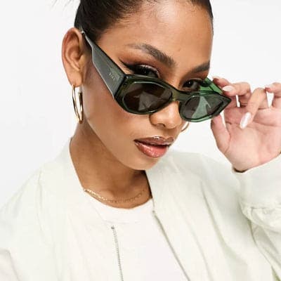 Sunglasses worn with a cream jacket